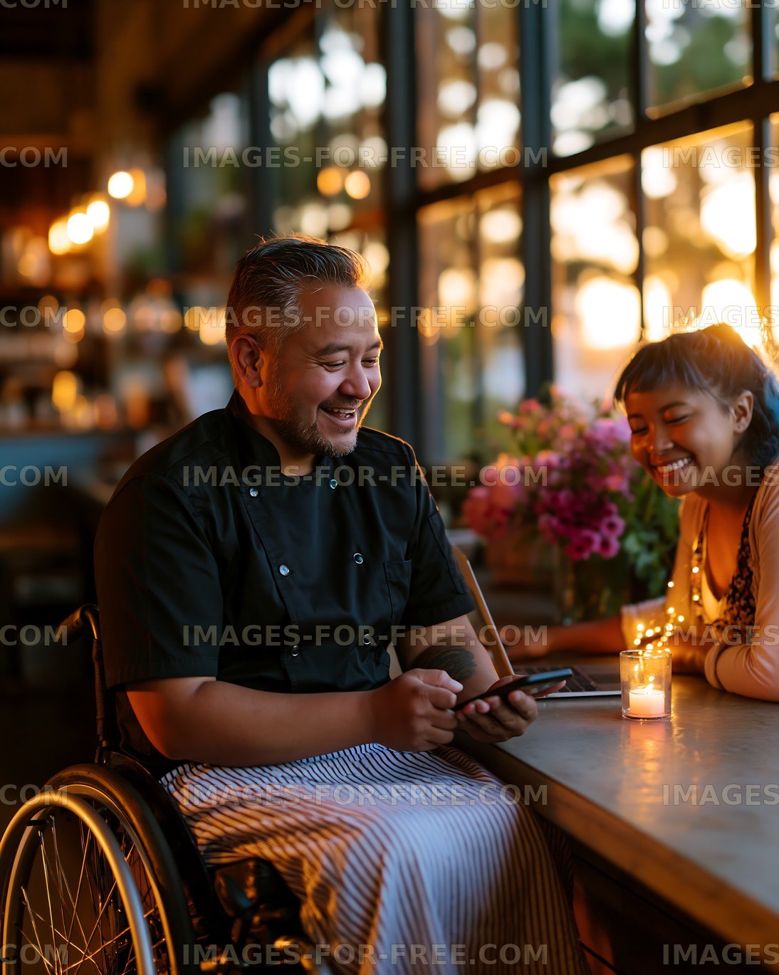 Chef in wheelchair smiles while talking with a guest at sunset