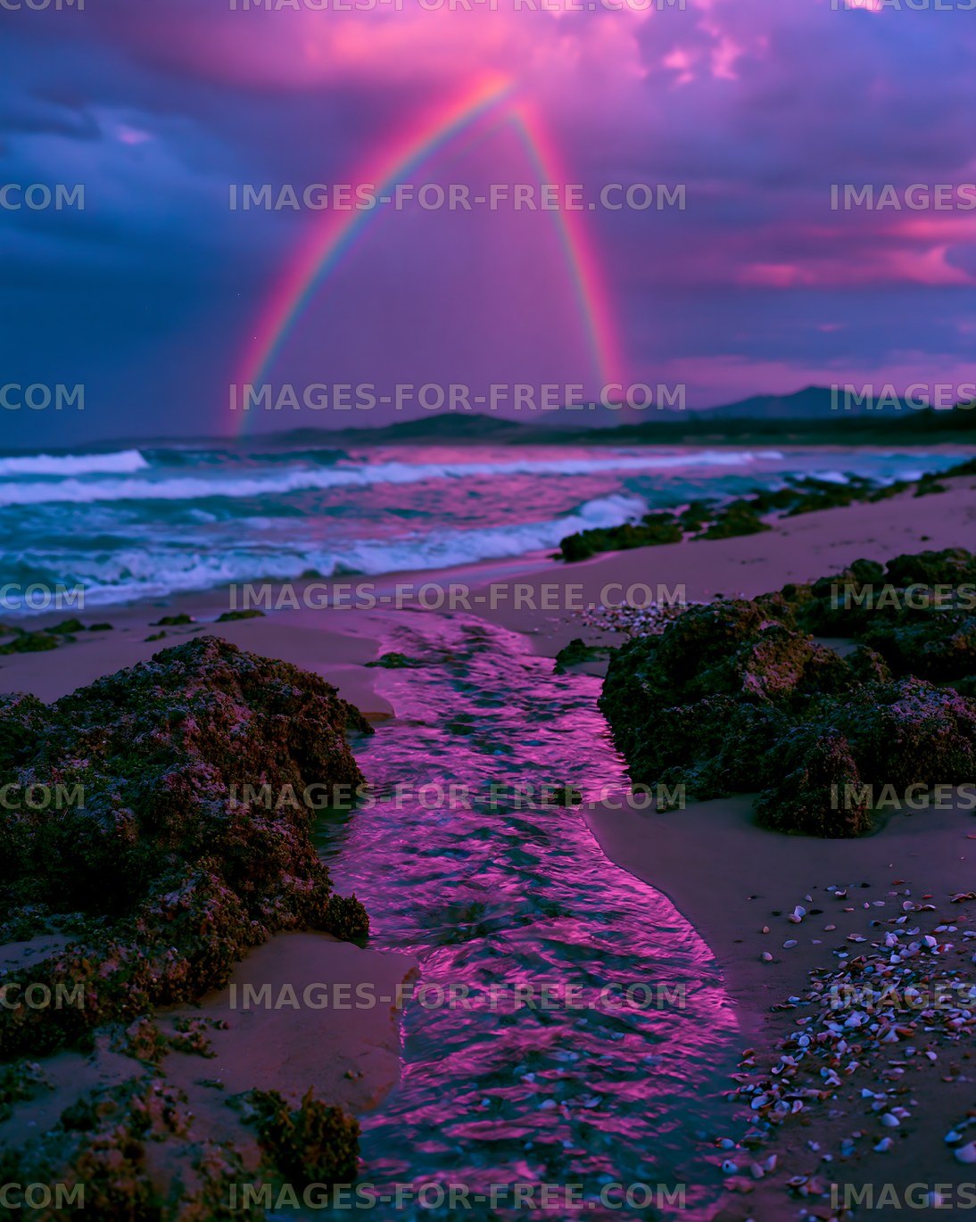 Vivid rainbow arcs over ocean waves and sandy shore at sunset