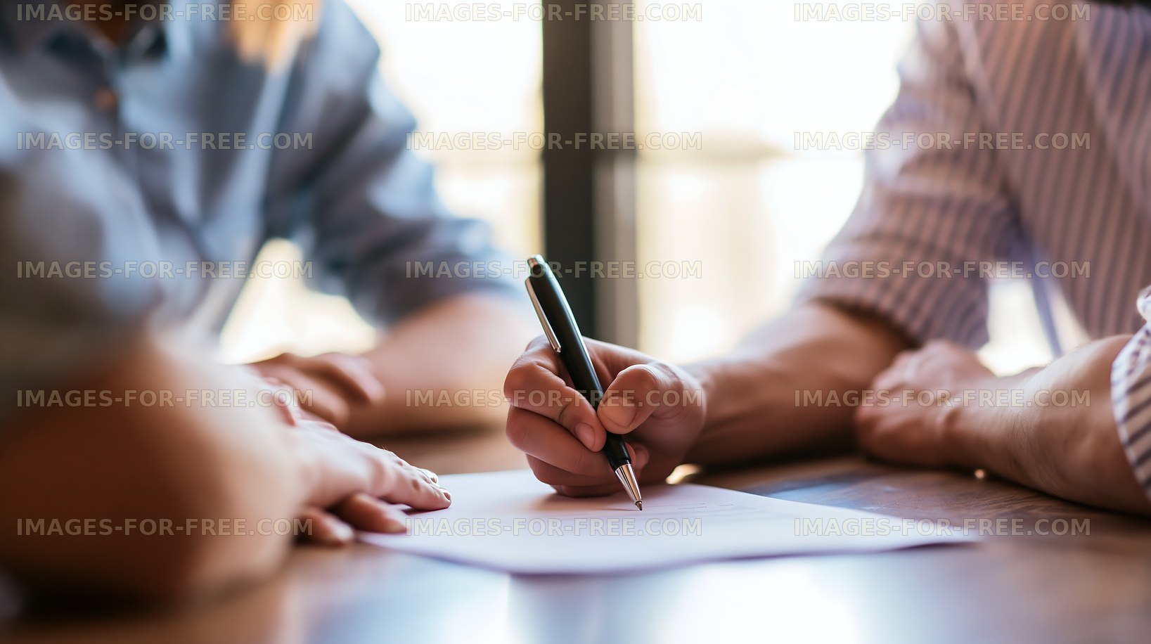 Group of people signing a document at a table in an office setting