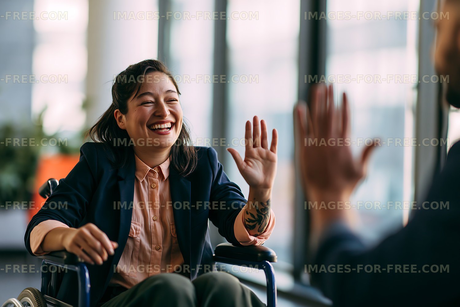 Woman in wheelchair smiling and waving during conversation indoors