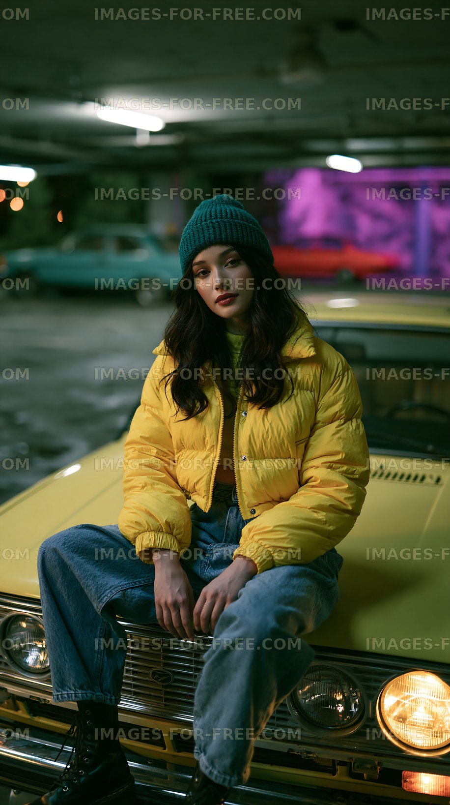 Young woman sits on yellow car in garage at night
