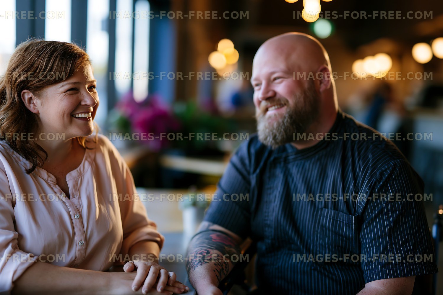 Two people smiling and talking in a cafe