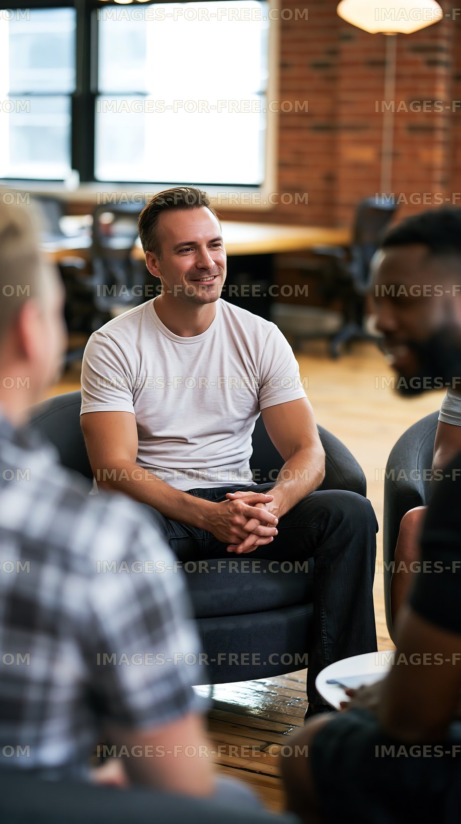 Smiling man seated during a group conversation