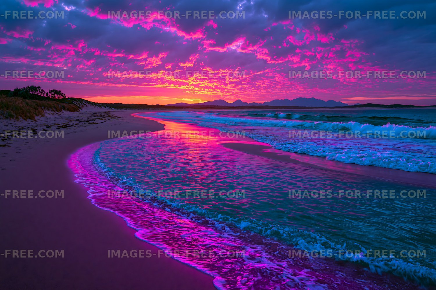 Colorful sunset shoreline with ocean waves and mountain silhouettes