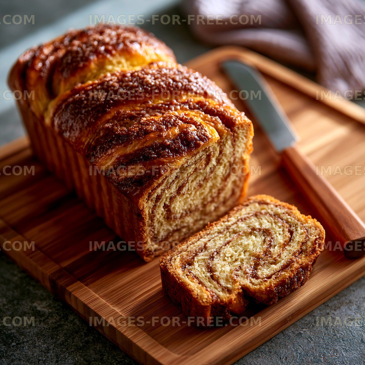 Freshly baked bread on a wooden board with a knife
