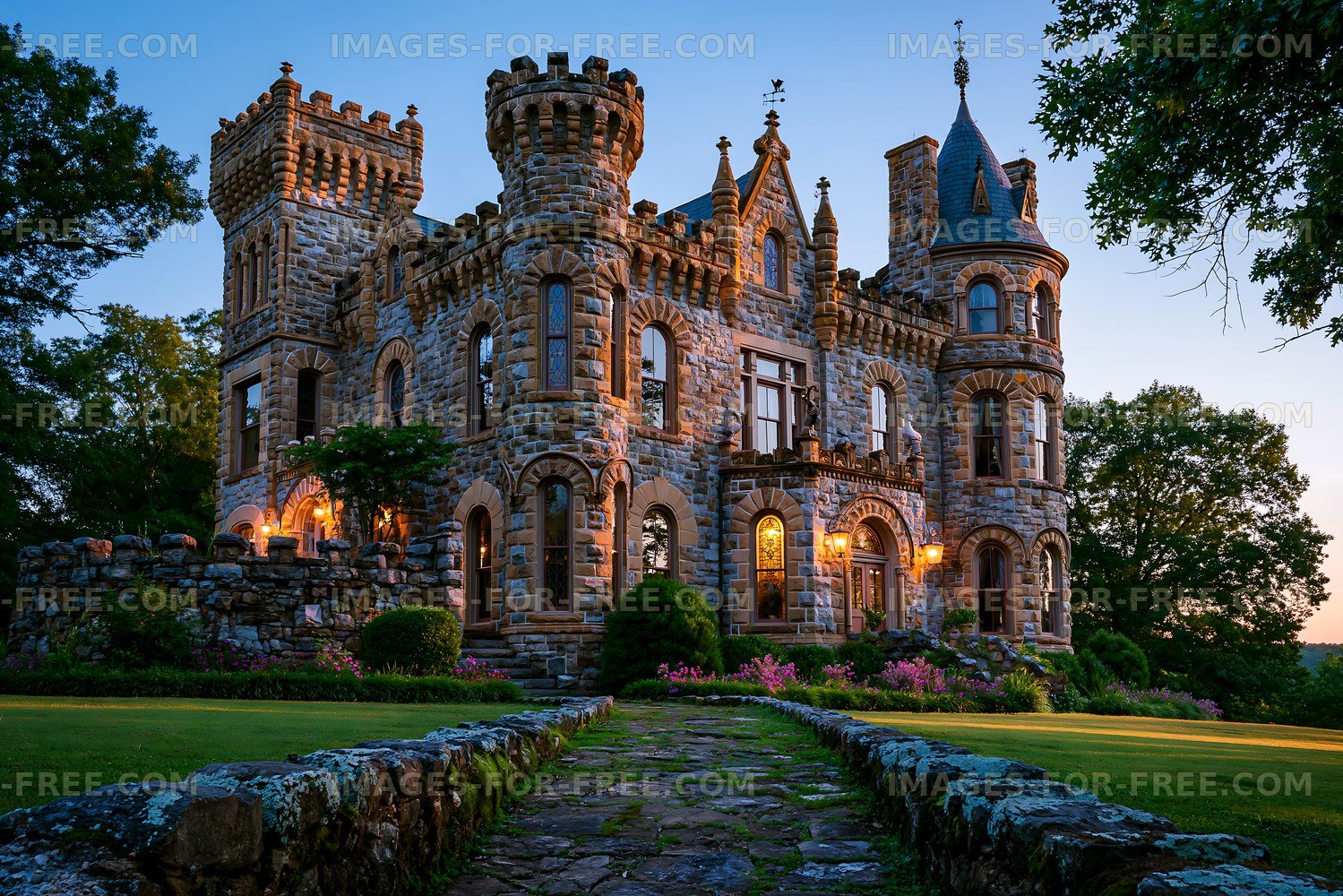 Grand stone castle surrounded by gardens at dusk
