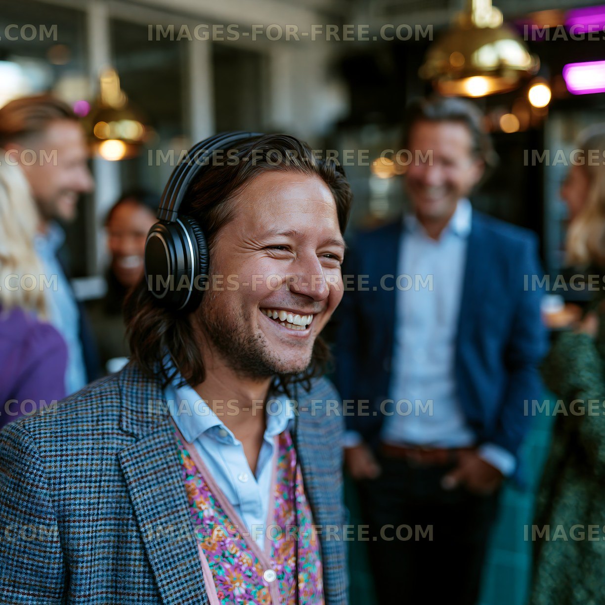 Happy man with headphones in a warmly lit indoor gathering