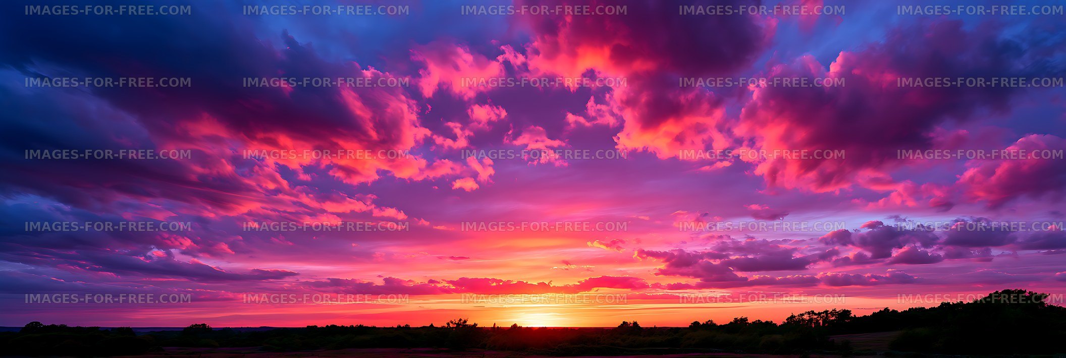 Colorful sunset clouds above a silhouetted landscape