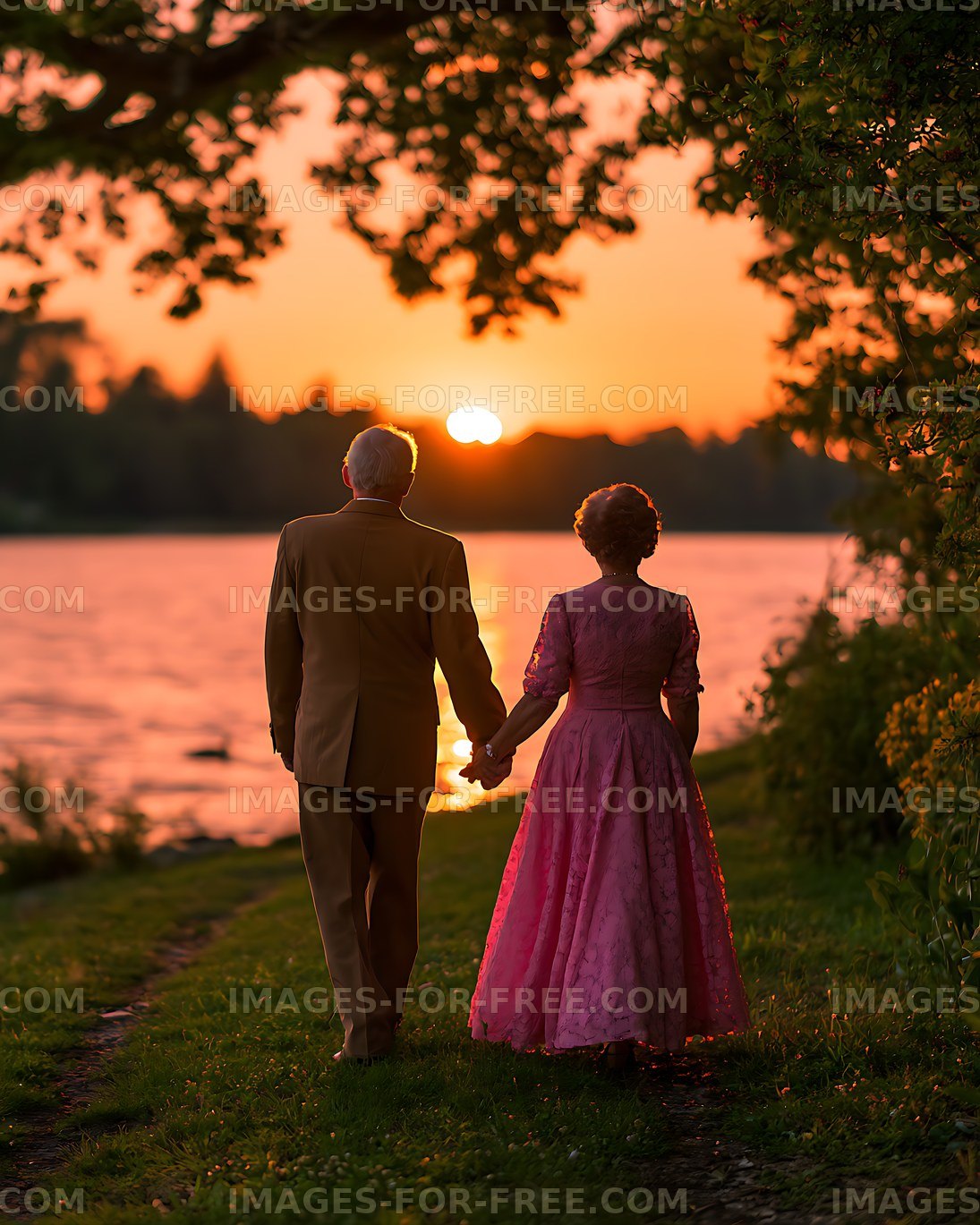 Couple holding hands beside a lake in golden sunset light