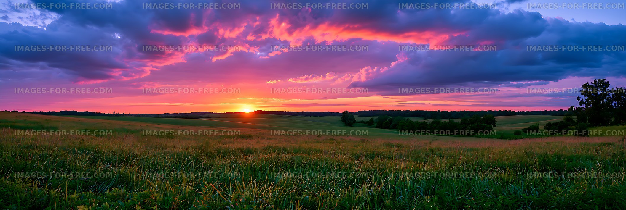Colorful sunset above green countryside fields