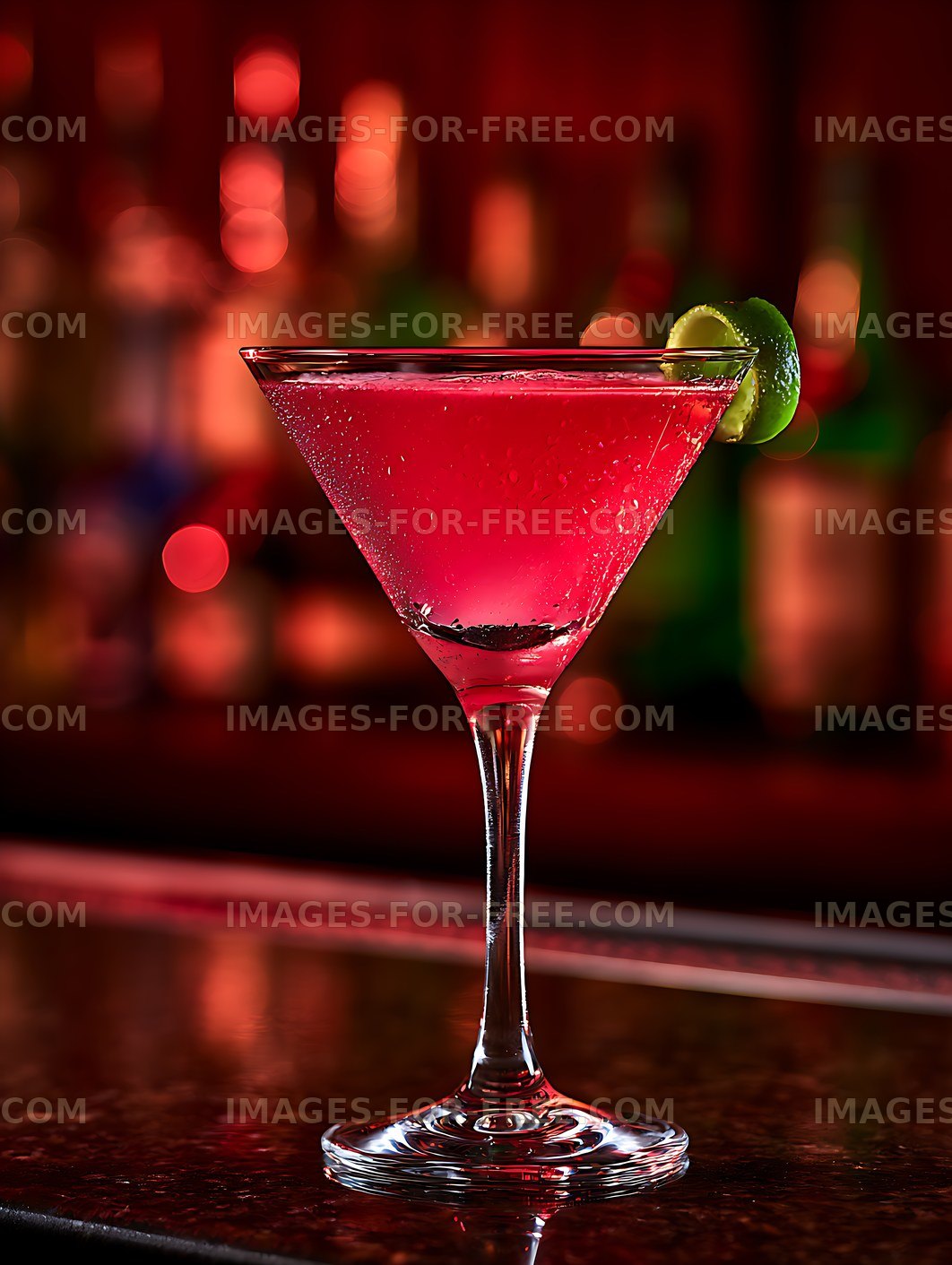 Vibrant red cocktail with lime on a reflective bar