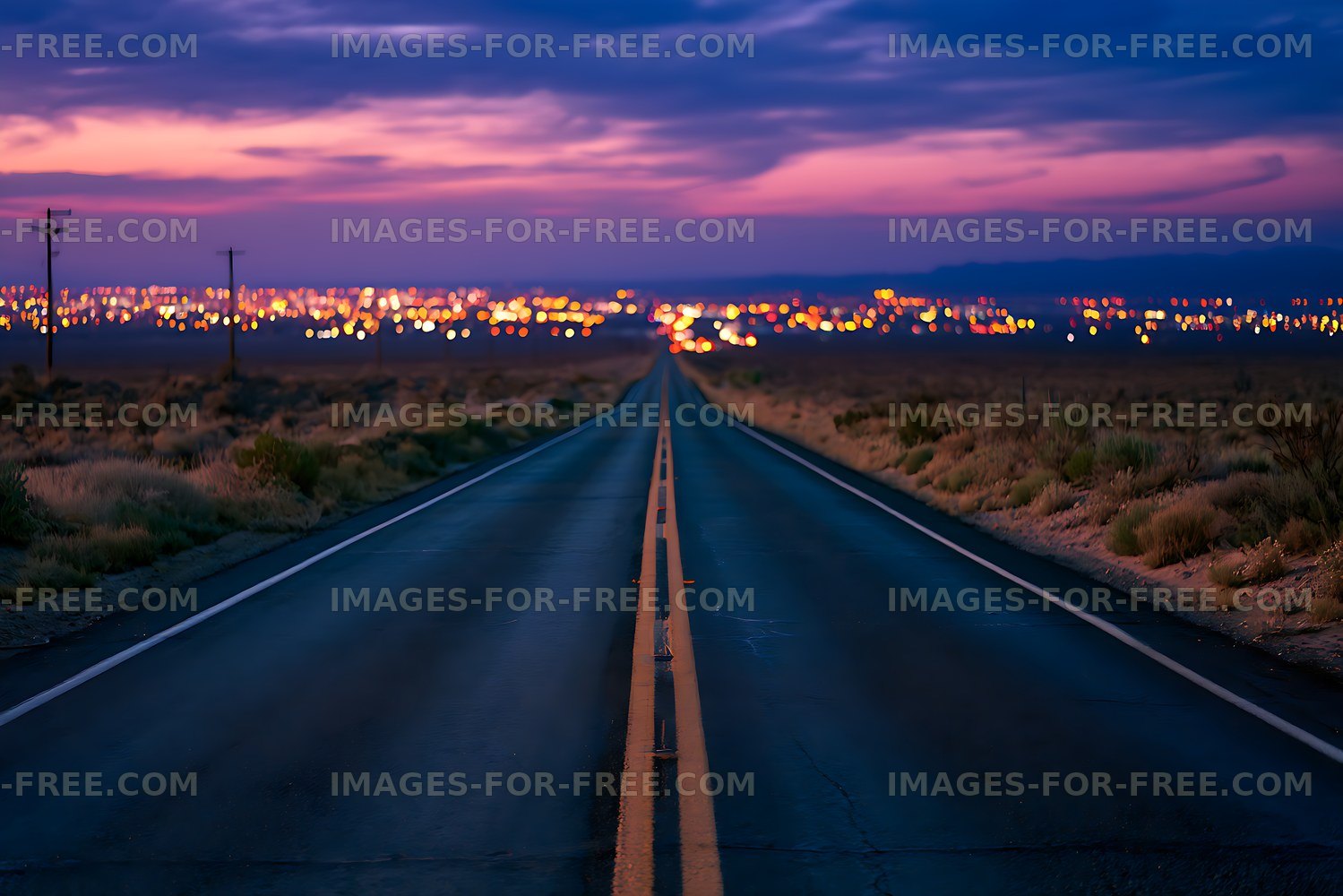 Wet desert road and glowing city lights at dusk