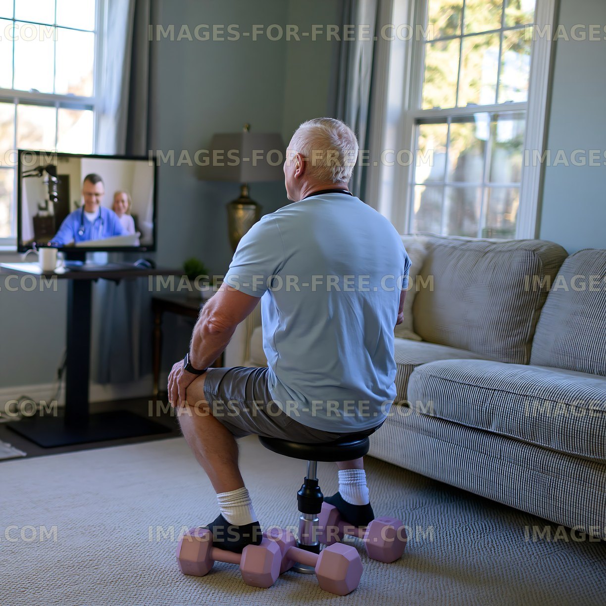 Senior man watching a telehealth appointment while exercising at home