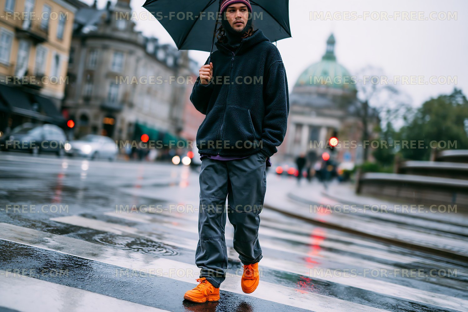 Person crossing a wet street under an umbrella