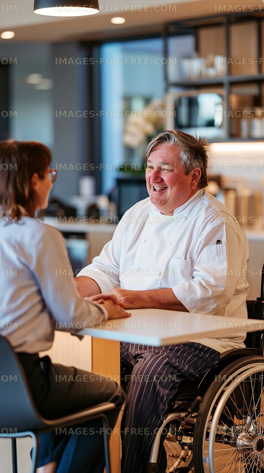 Smiling chef talking with customer at restaurant table