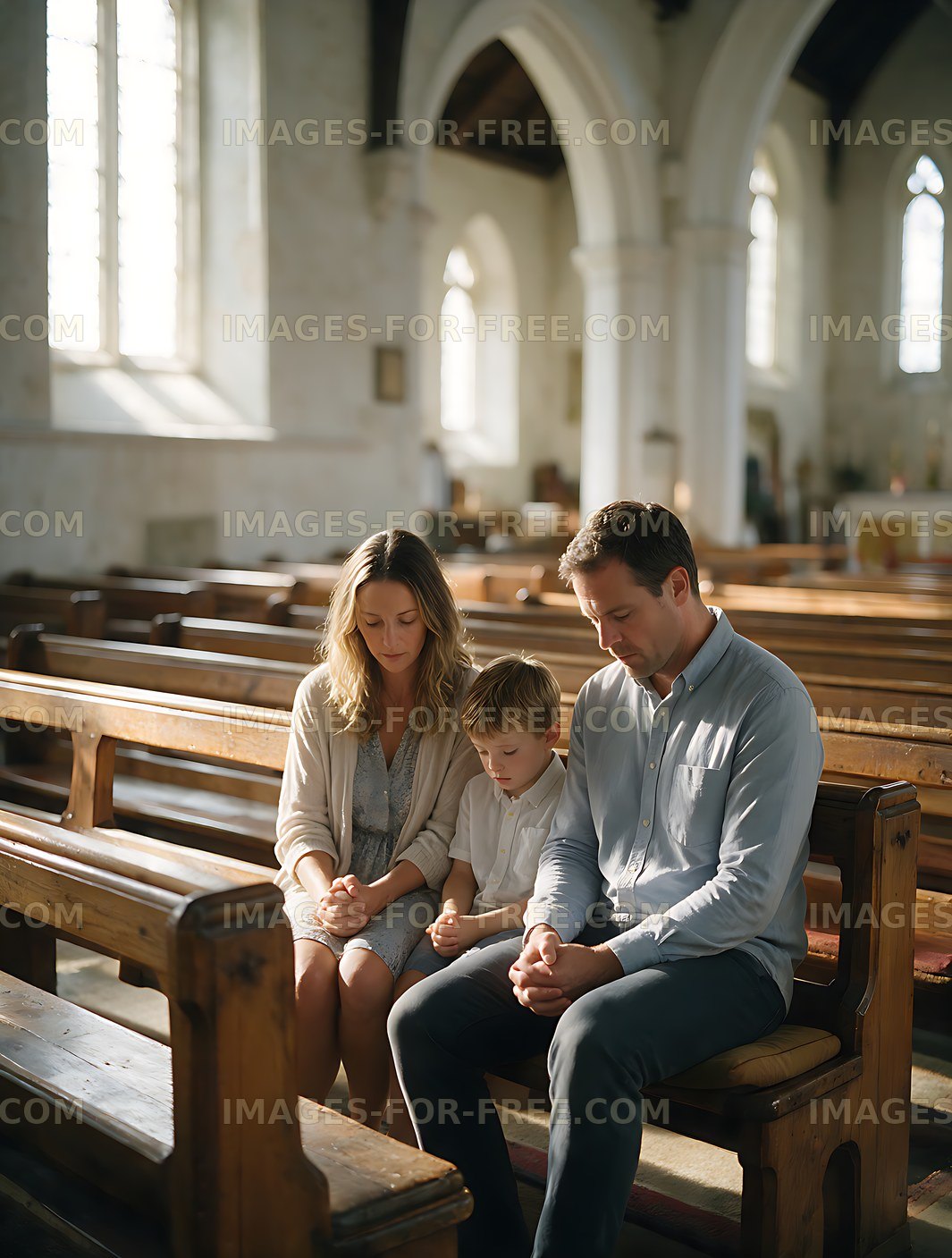 Family of three praying in a church pew