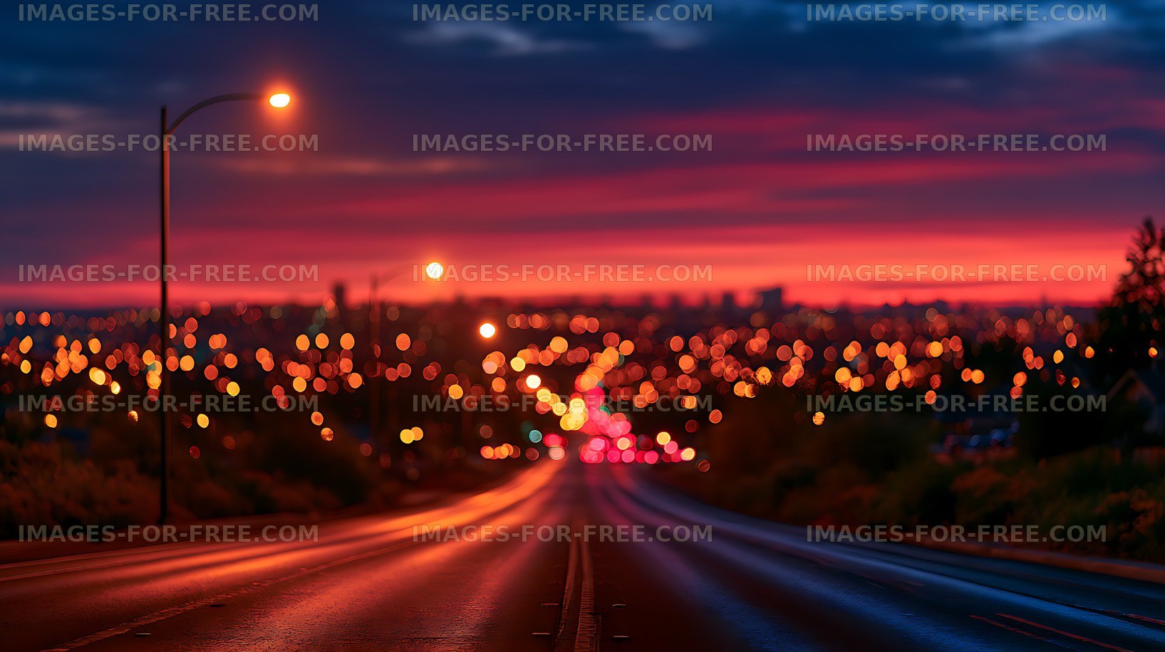 Defocused urban road glowing beneath a colorful sunset