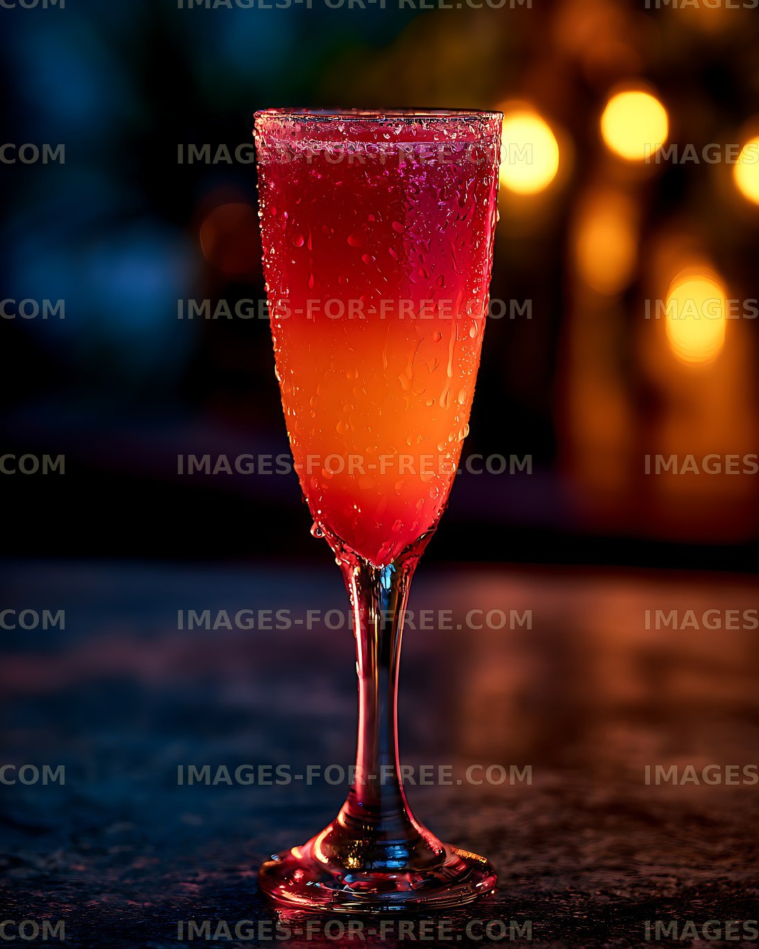 Red-orange beverage in a chilled glass with colorful bokeh