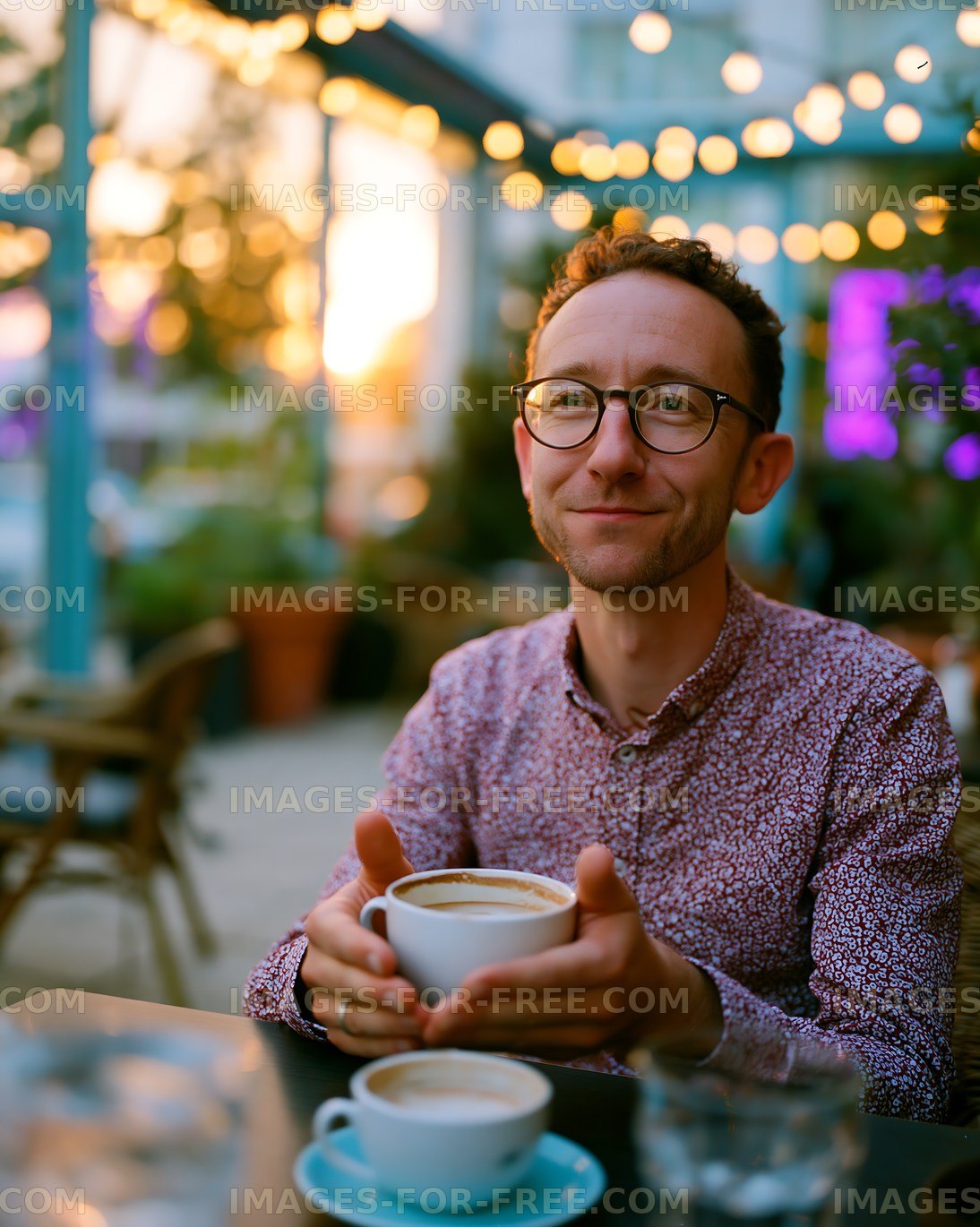Man enjoying coffee at outdoor cafe during sunset