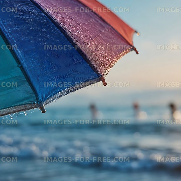 Raindrops on colorful umbrella with beach background