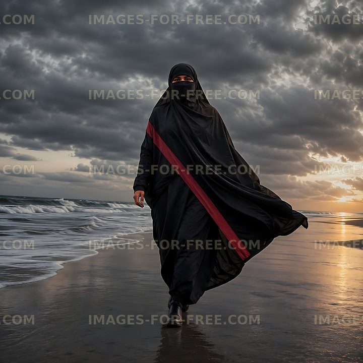 Woman walking on beach at sunset with flowing black attire