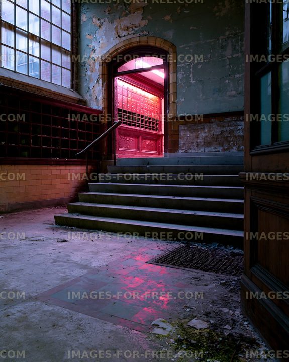 Old building interior with stairs and glowing doorway