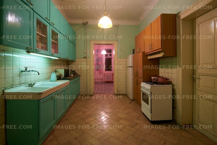 Kitchen with teal cabinets and wooden floors in a vintage apartment