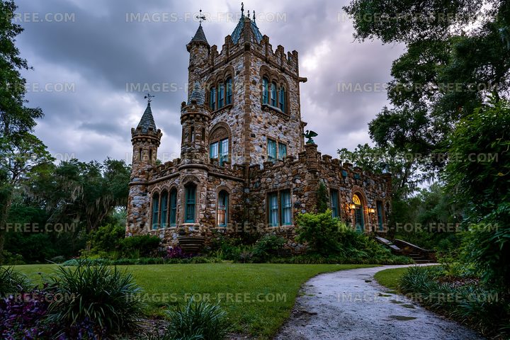 Historic stone castle surrounded by trees in evening light