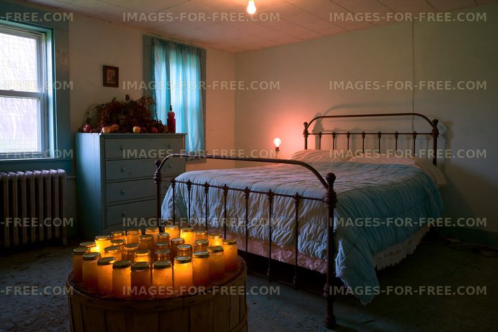 Bedroom with jars of glowing lights and a bed in a simple setting