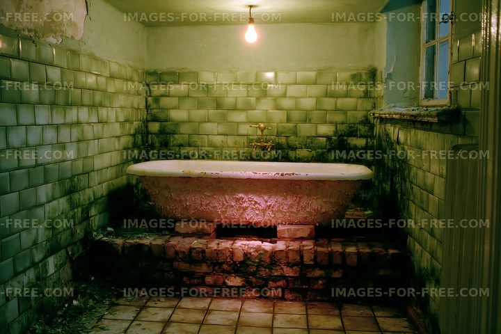 Old bathroom with a vintage bathtub and green tiled walls