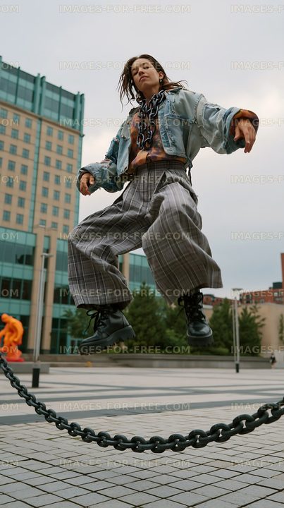Woman jumping above a chain in urban environment
