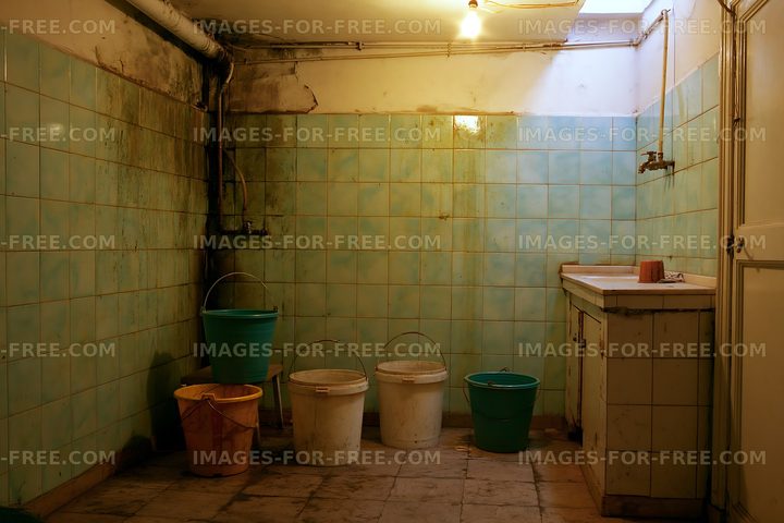 Old tiled room with buckets and a sink in a basement area