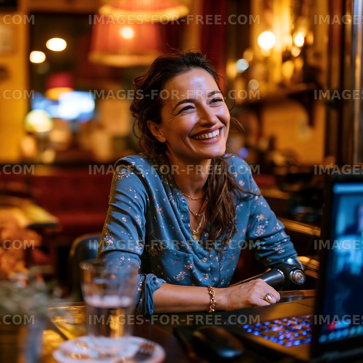Woman in blue blouse smiling at a table in a bar