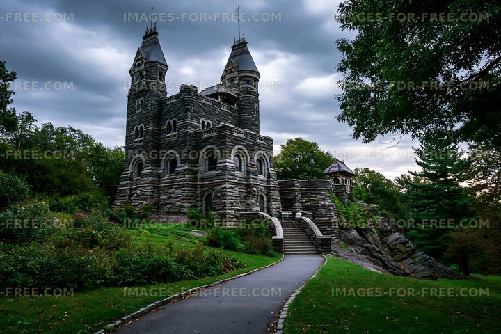 Stone castle with towers amidst cloudy skies in a park