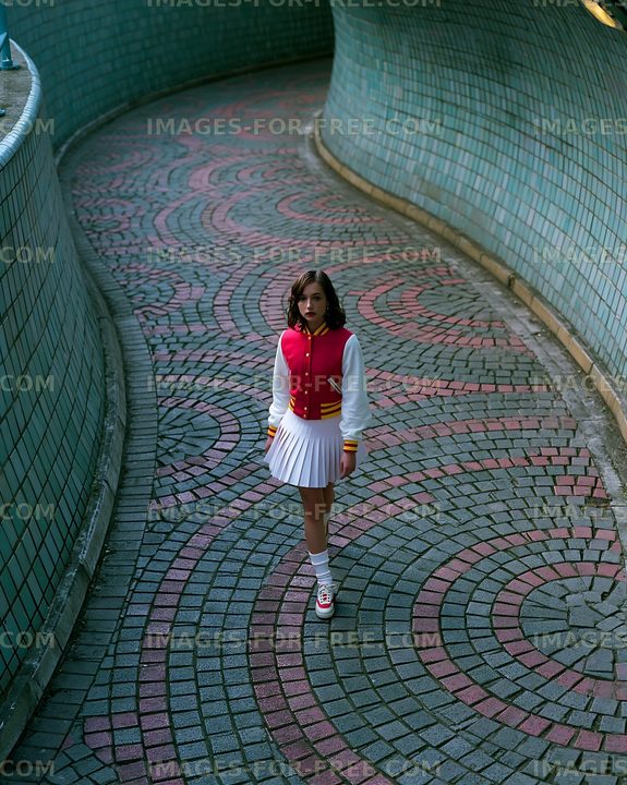 Young woman walks in a curved brick path with a colorful design