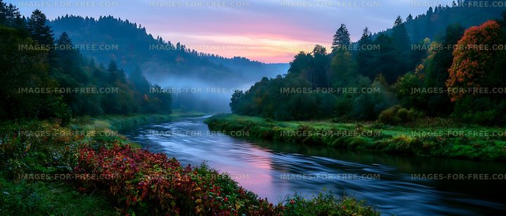 River flows through forested hills under dawn sky