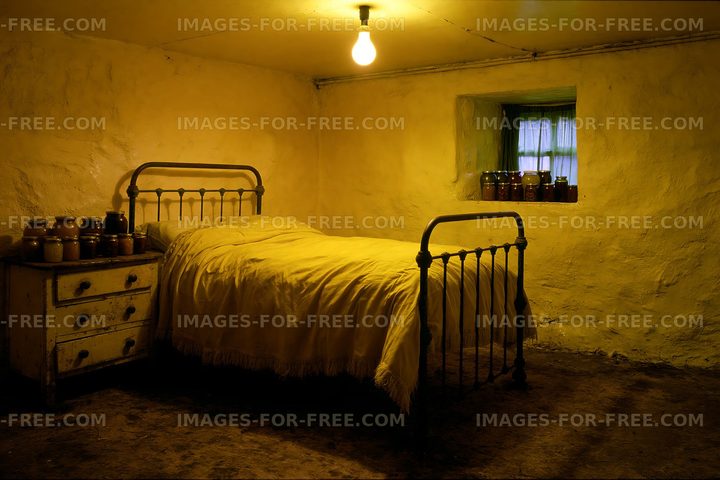 Old bedroom with a bed and jars on a windowsill