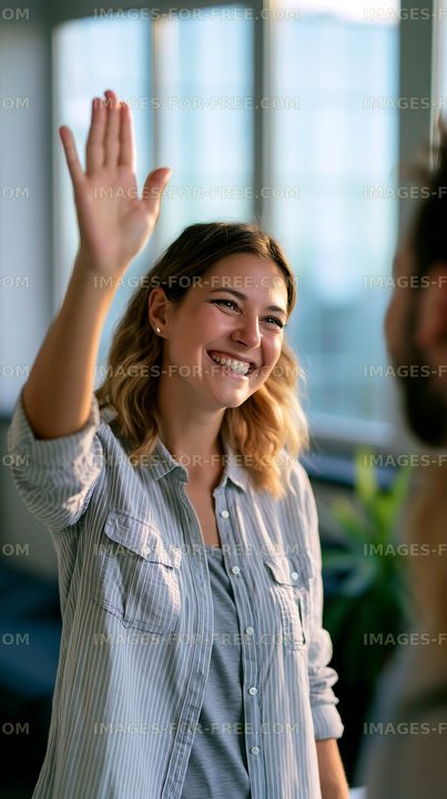 Person smiling and waving in an office setting during daylight