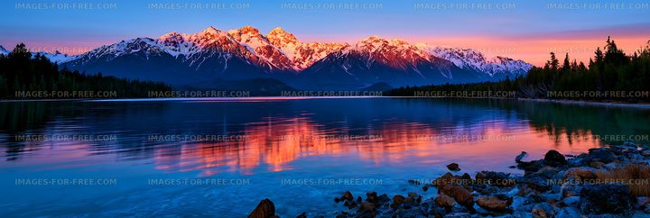 Sunset reflections of snowy peaks on an alpine lake
