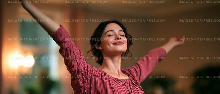 Happy woman celebrating with arms outstretched indoors