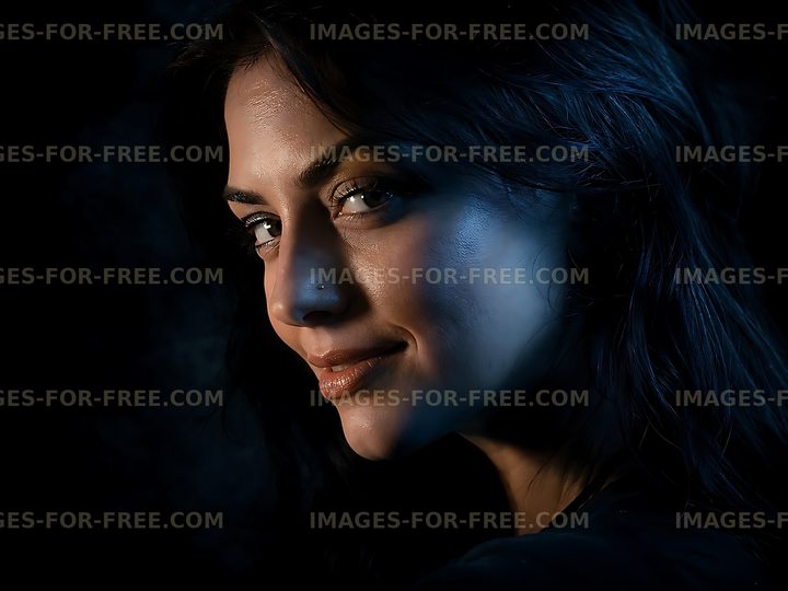 Woman with dark hair smiling softly in low light