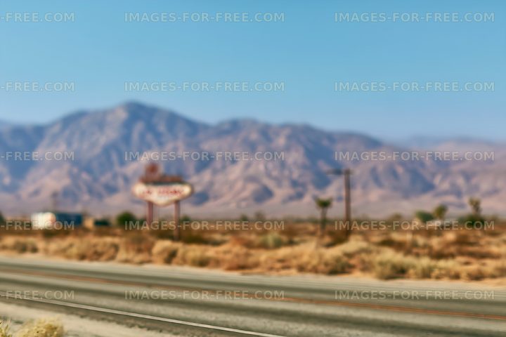 Soft-focus desert road and rugged mountains